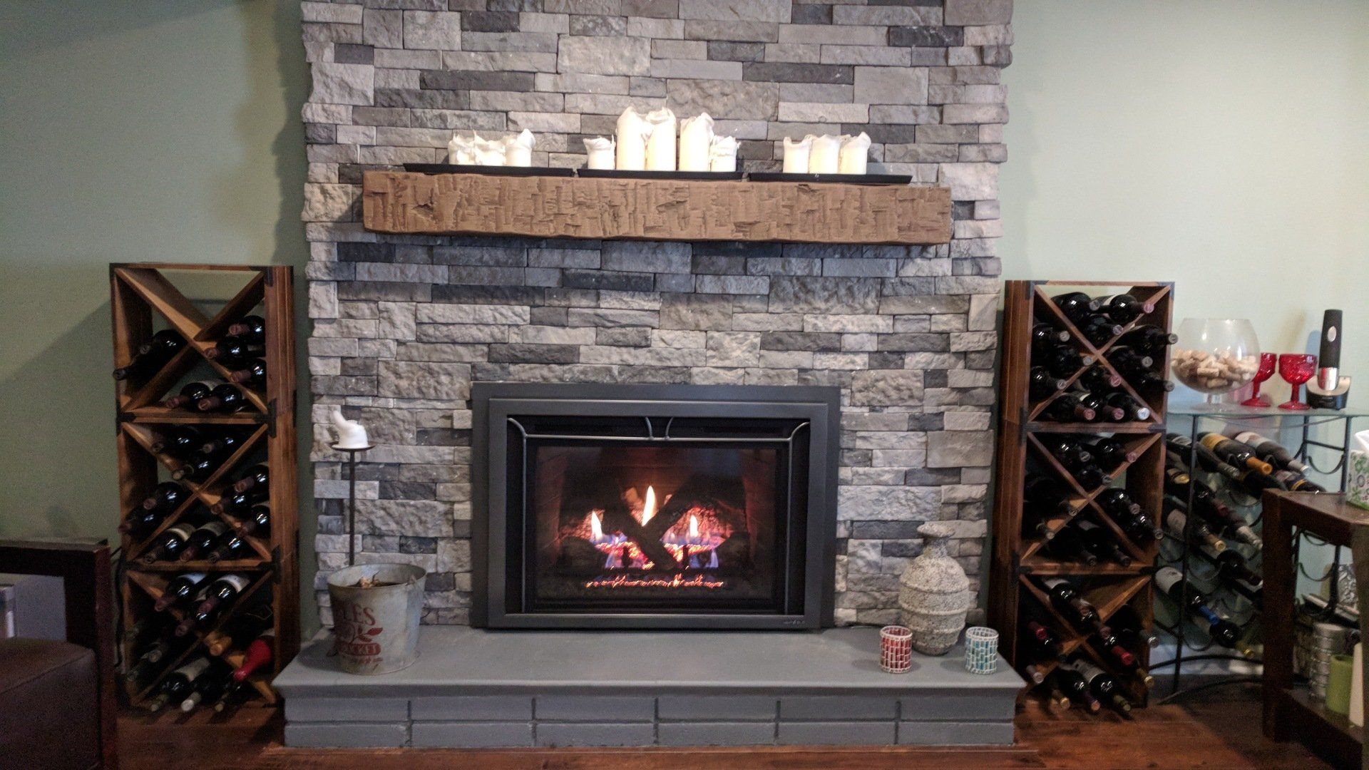 A living room with a fireplace and wine racks
