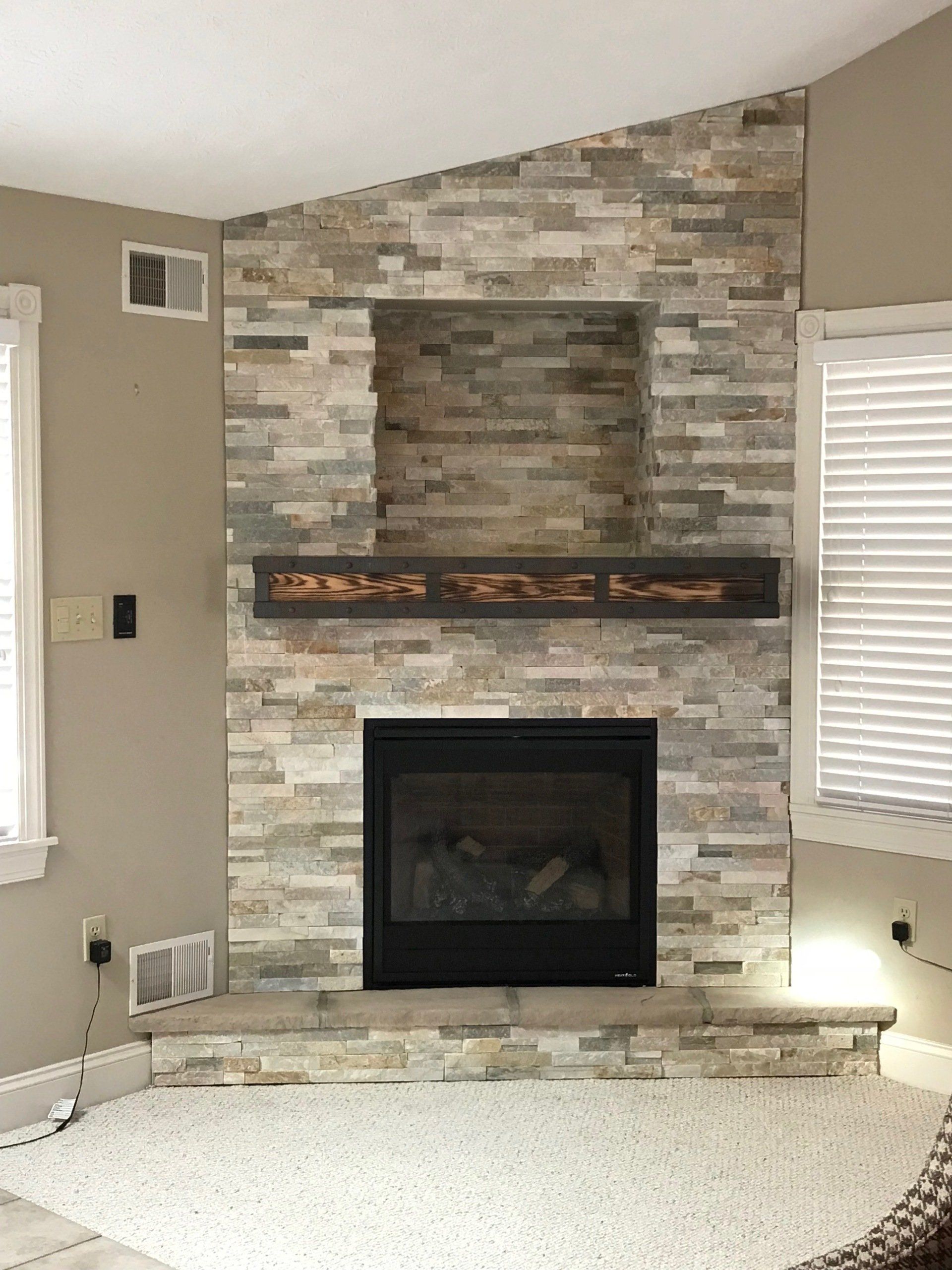 A living room with a fireplace and a stone wall