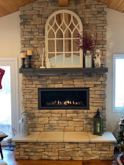 A living room with a fireplace and a mirror above it