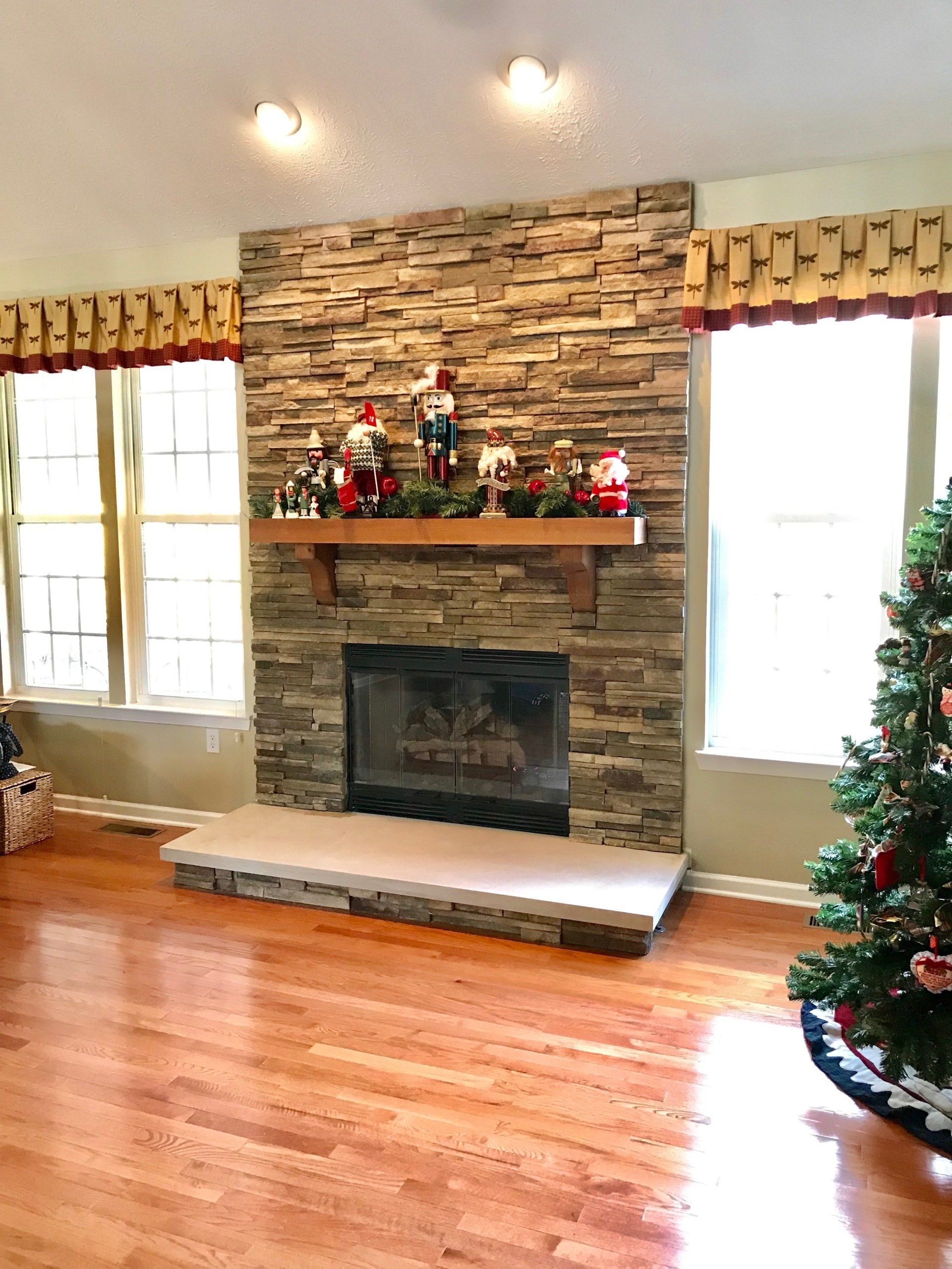 A living room with a fireplace and a christmas tree.