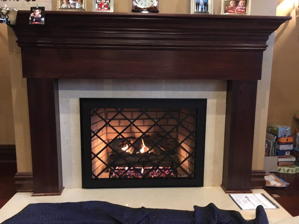 A fireplace in a living room with pictures on the mantle