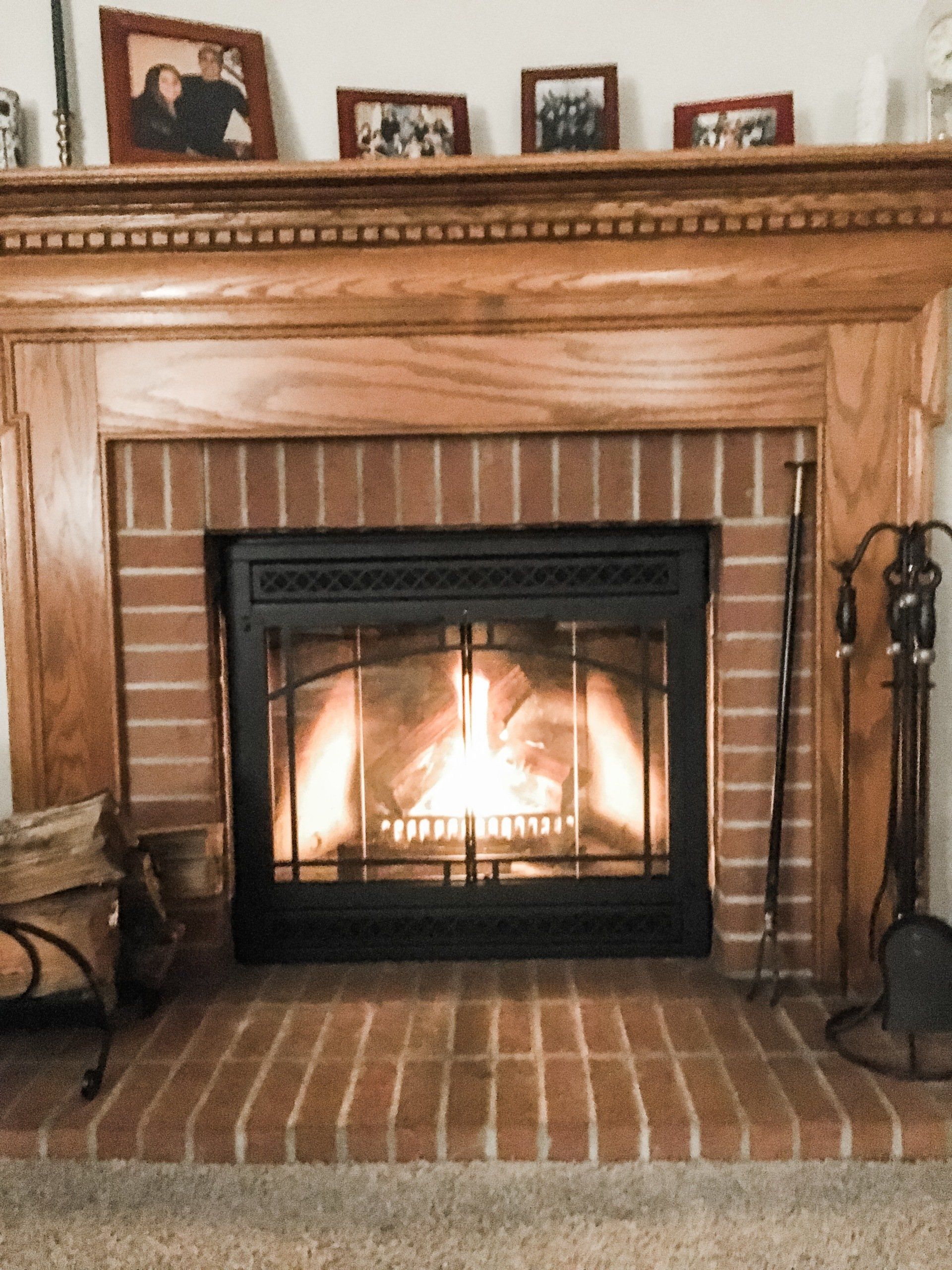 A fireplace in a living room with pictures on the mantle