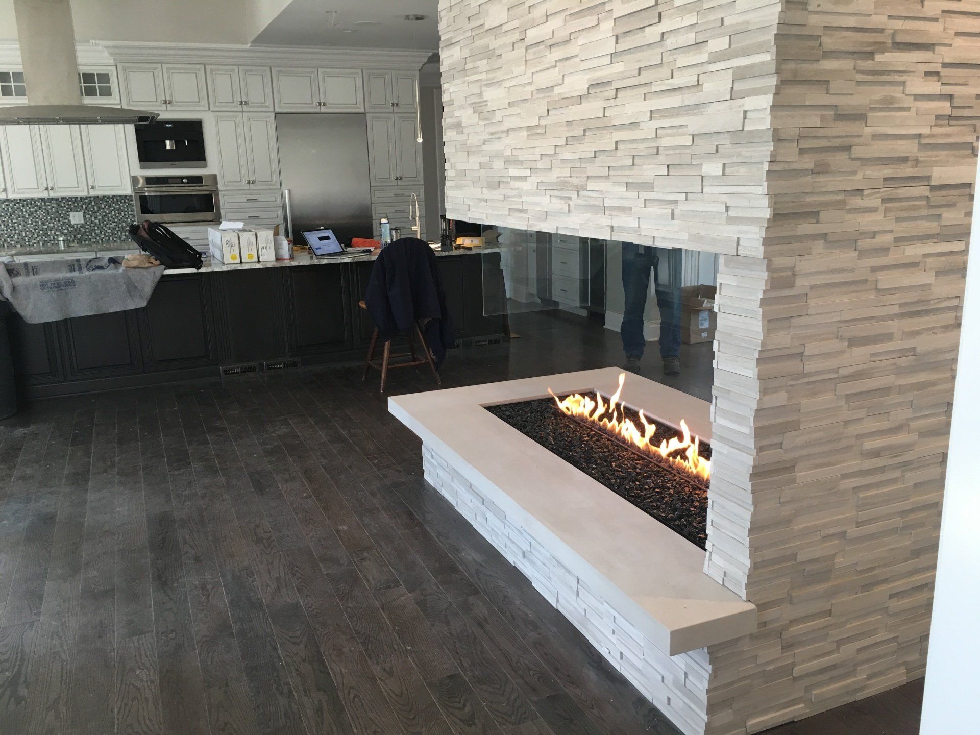 A kitchen with a fireplace in the middle of it