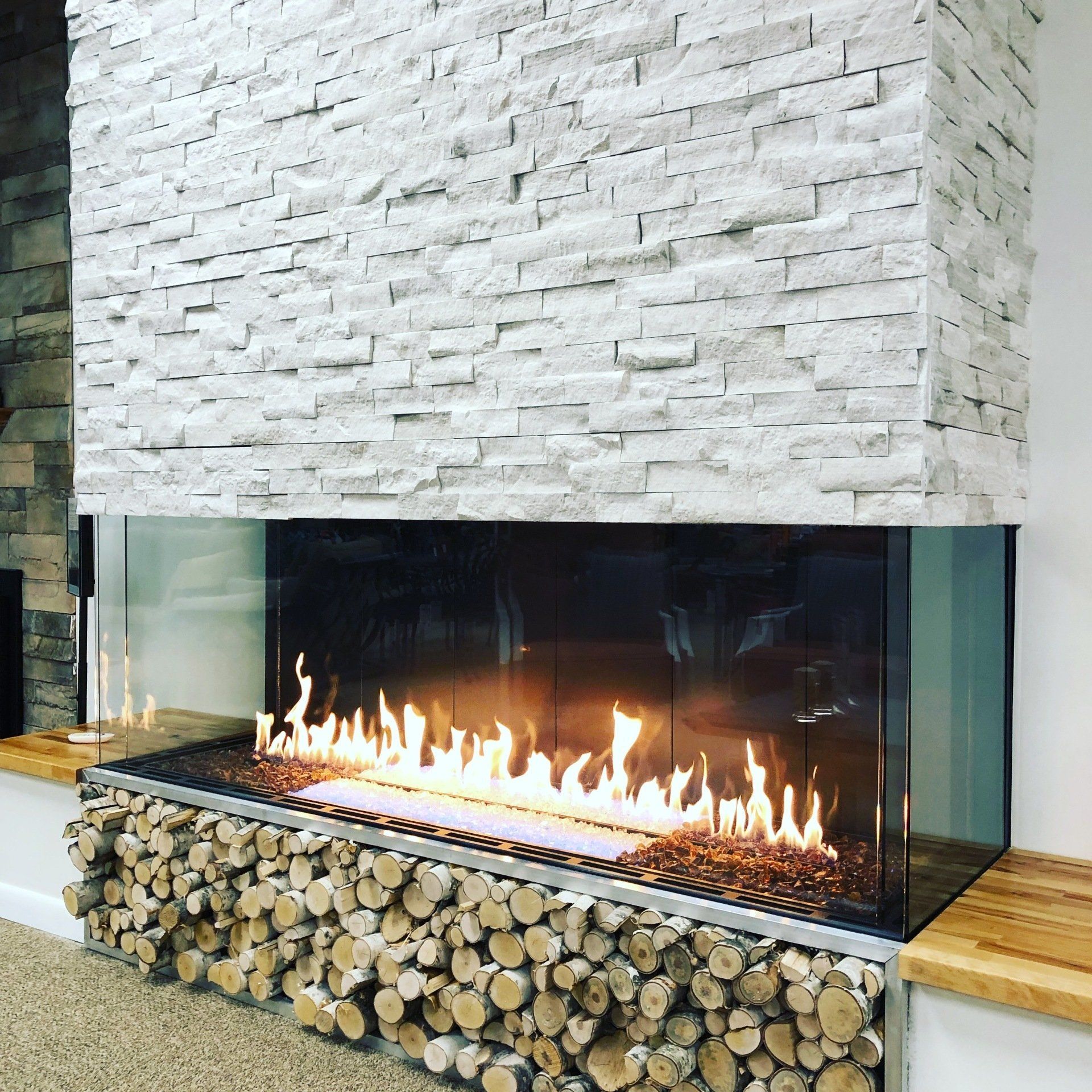 A fireplace with a lot of logs underneath it