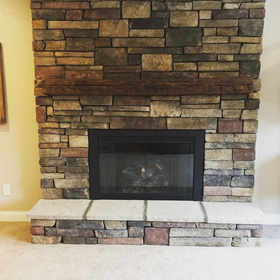 A brick fireplace with a black door in a living room