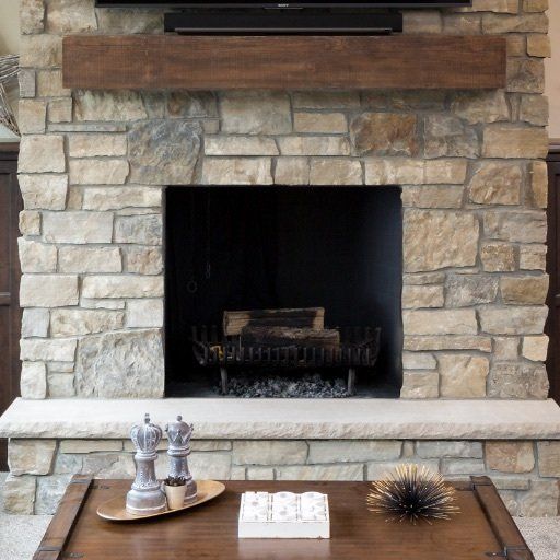 A stone fireplace with a tv above it