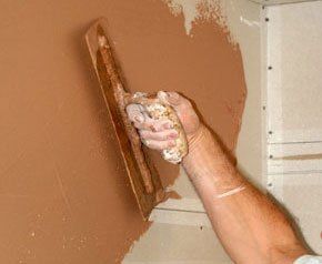For a professional plastering service contact us! A plasterer plastering a wall