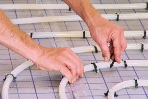 Need someone to install your underfloor heating? A plumber installing underfloor heating