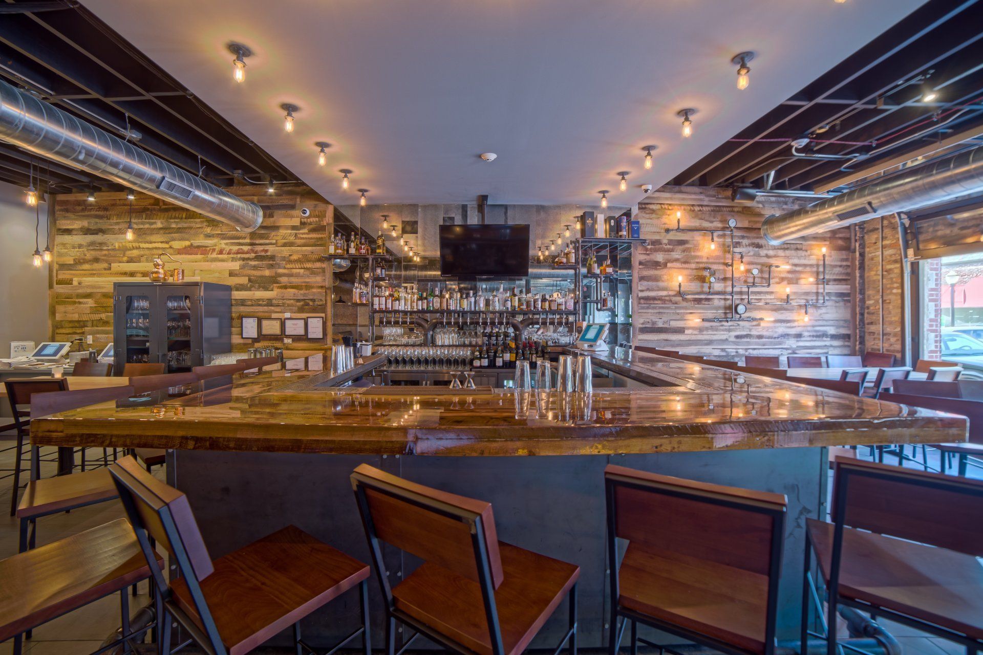 a restaurant with a long bar and tables and chairs .