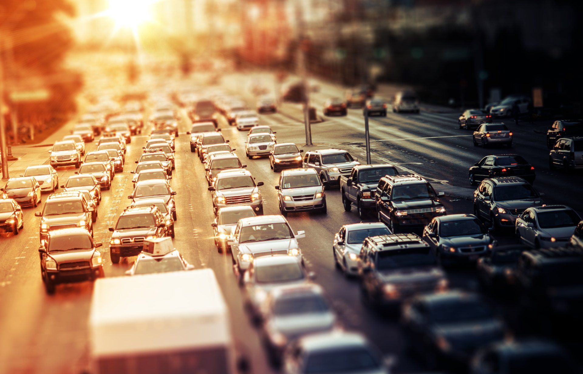 A lot of cars are driving down a busy city street.