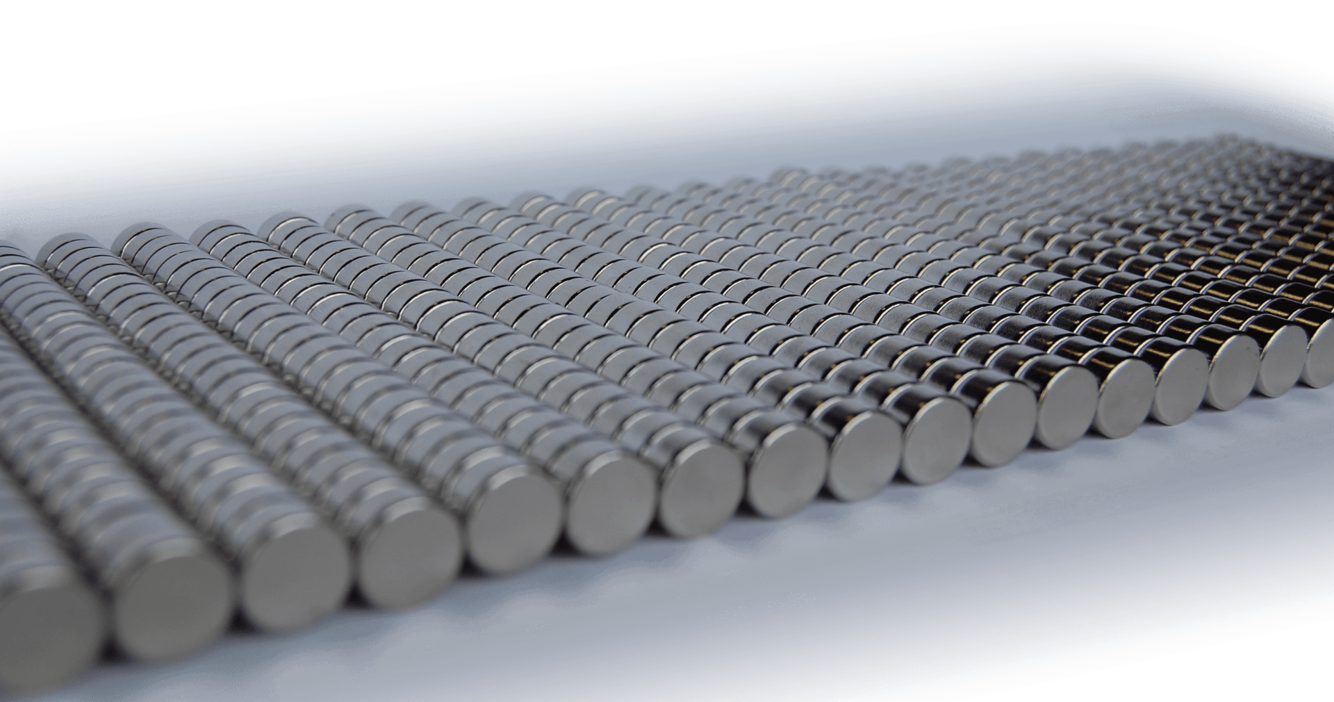 a row of metal rods stacked on top of each other on a white surface .