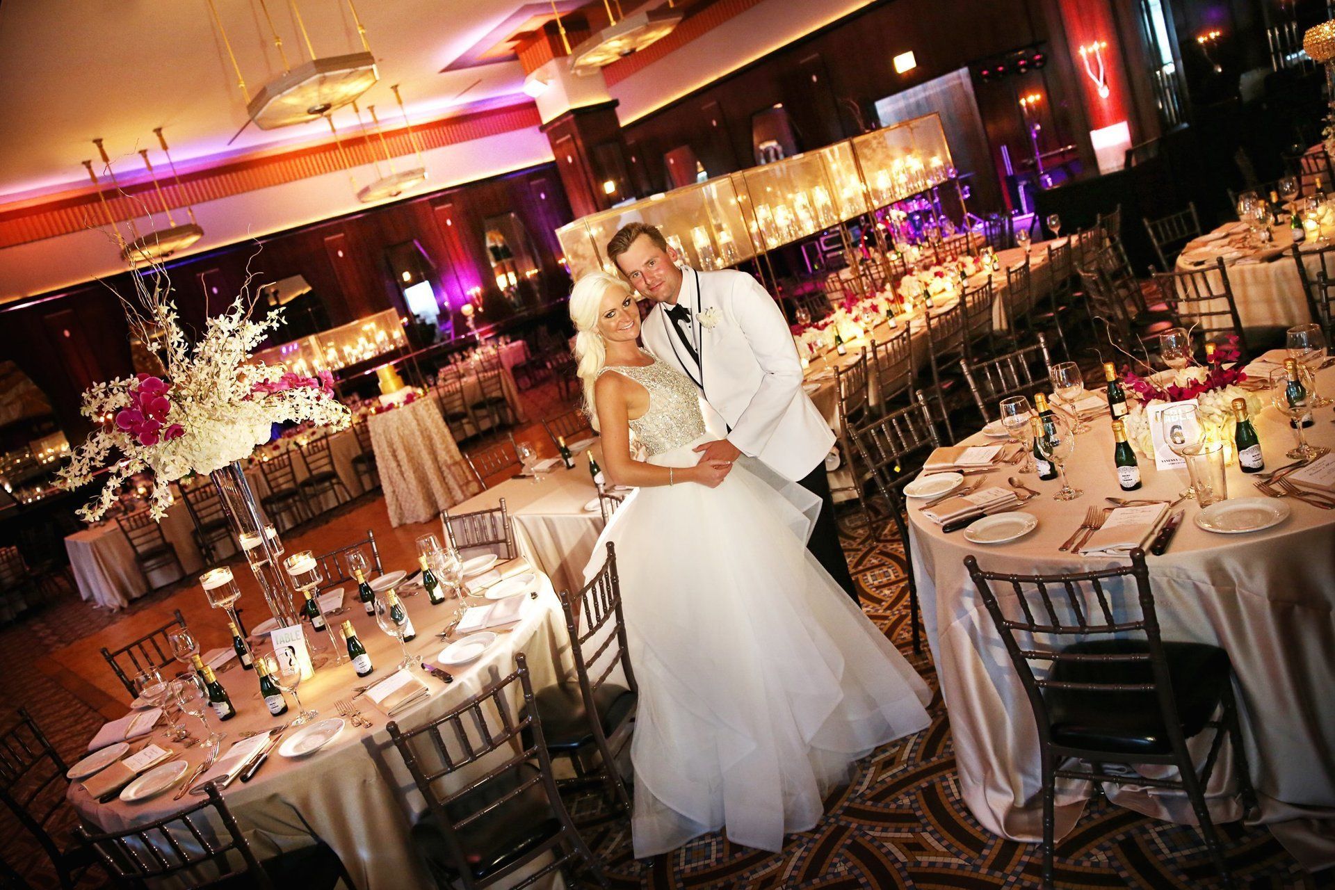 A bride and groom pose for a picture at their wedding reception