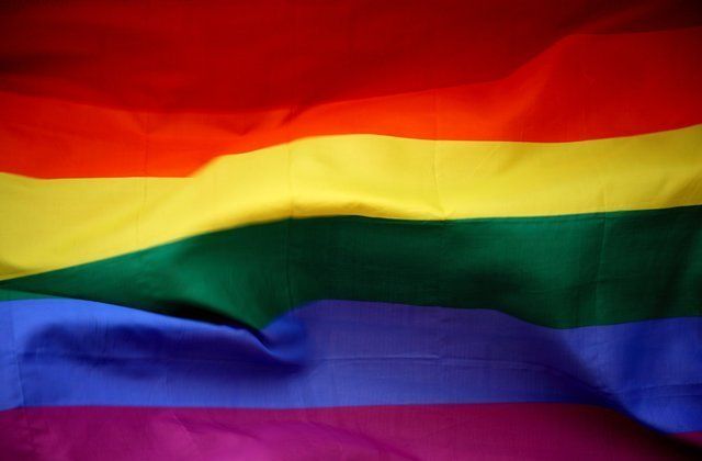 A close up of a rainbow flag waving in the wind.