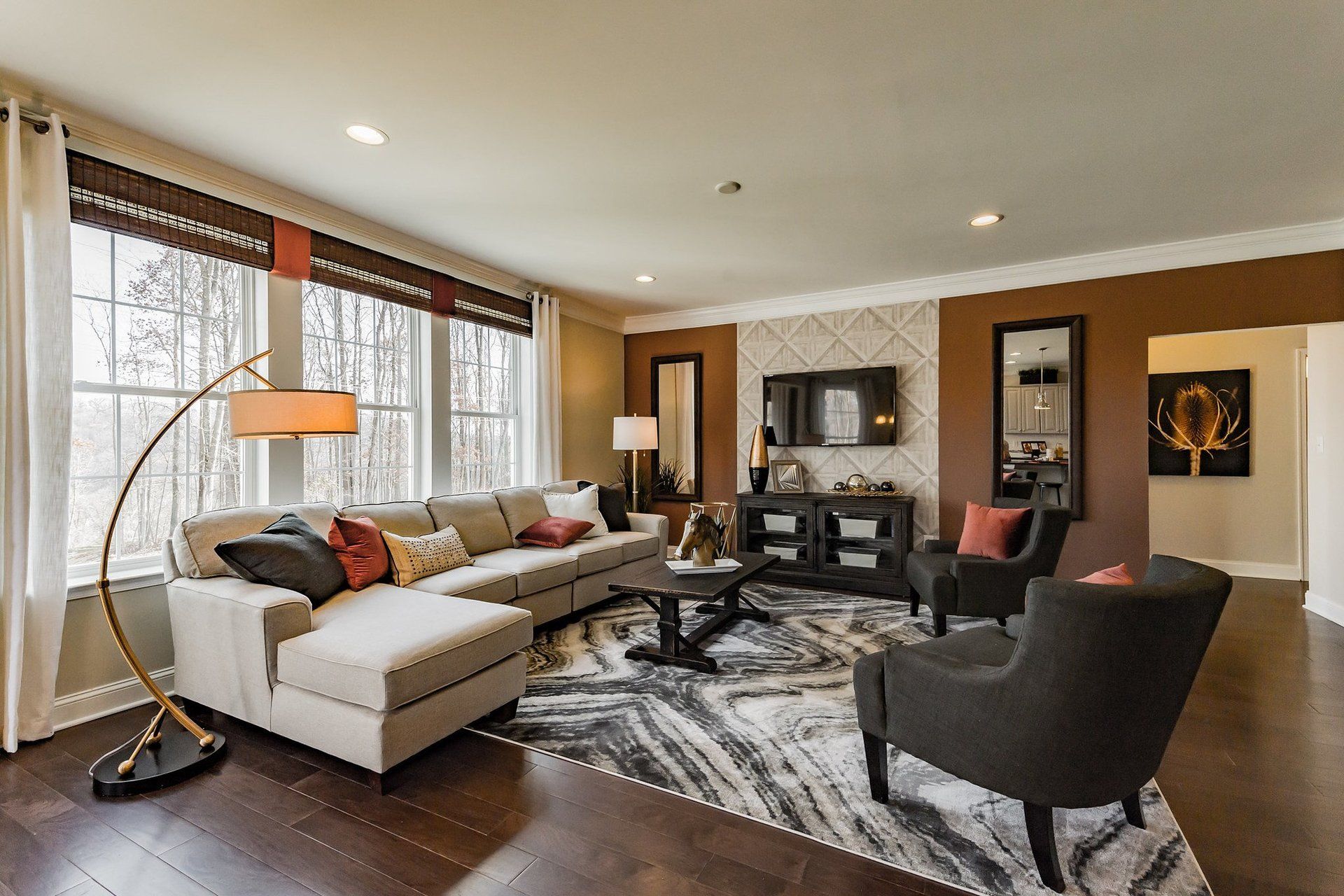 a living room with a couch , chairs , and a lamp .