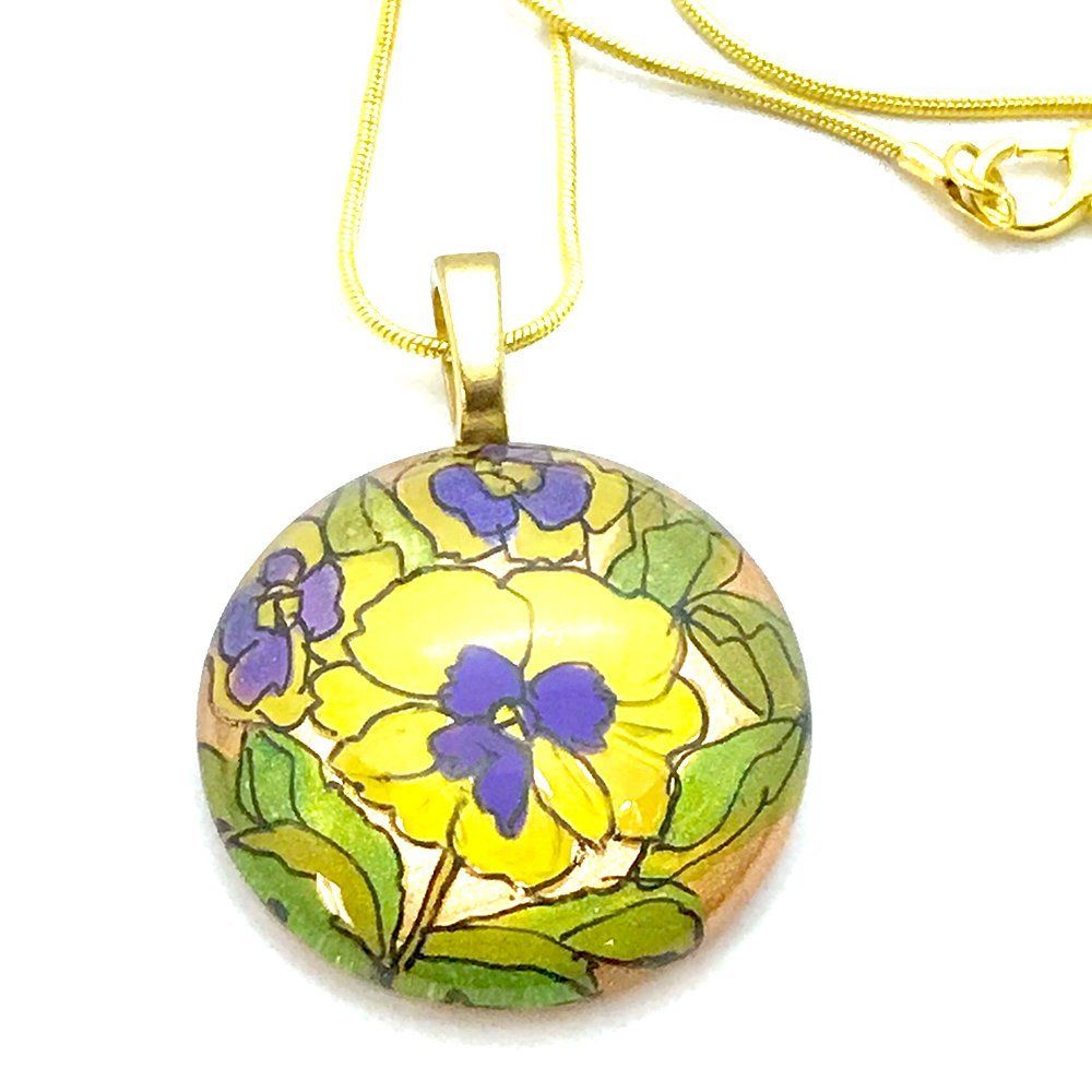 a yellow and purple flower pendant on a gold chain