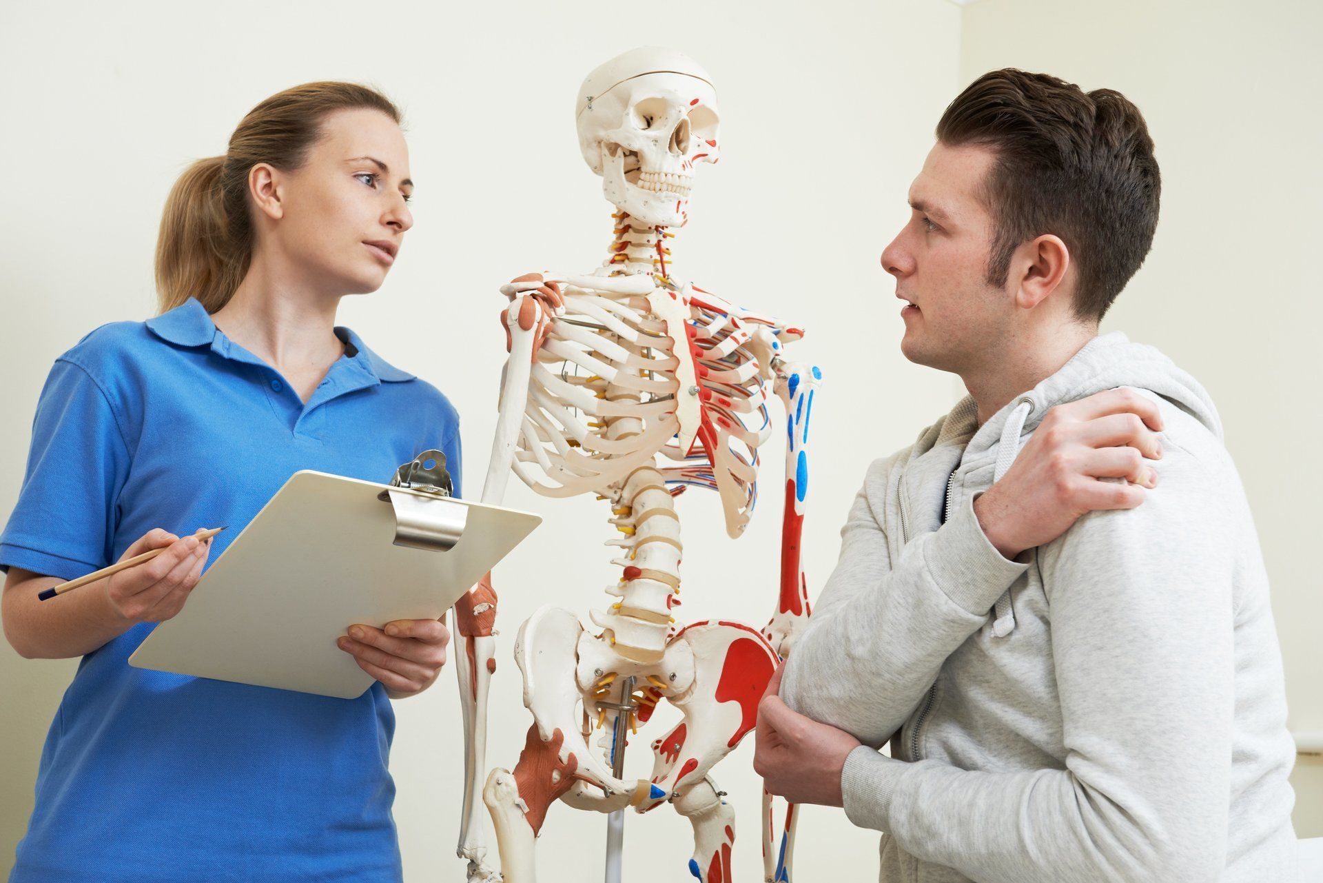 a woman is talking to a man in front of a skeleton .