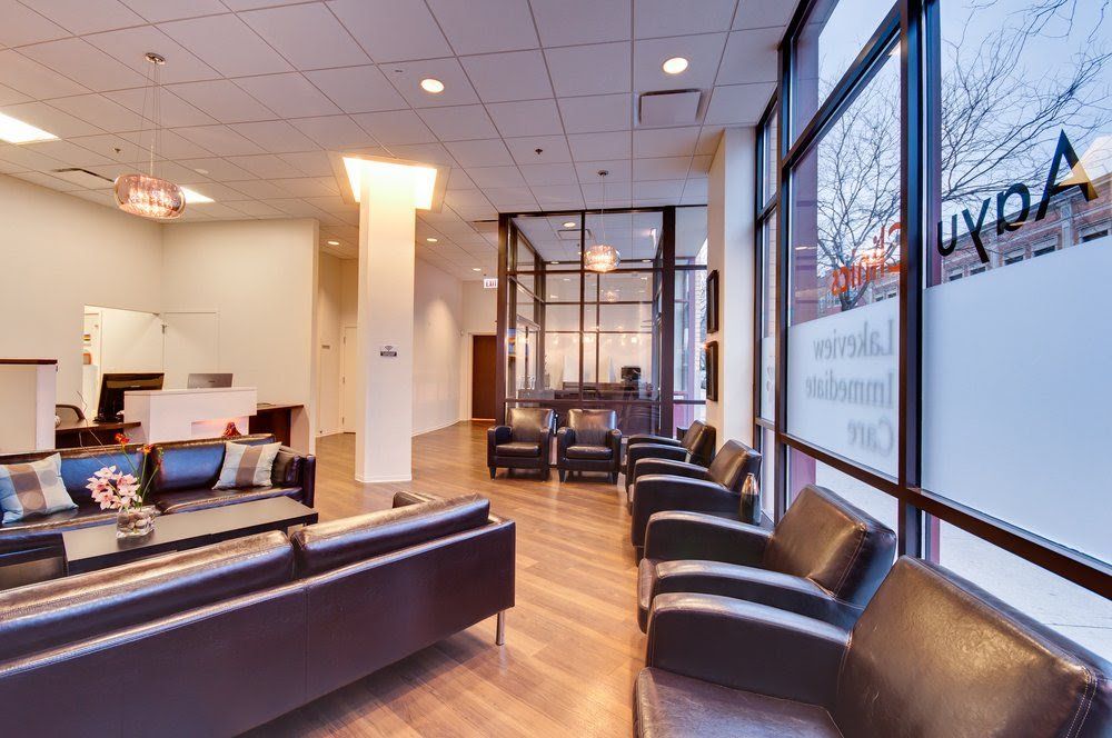 a living room with a couch , chairs , and a large window .