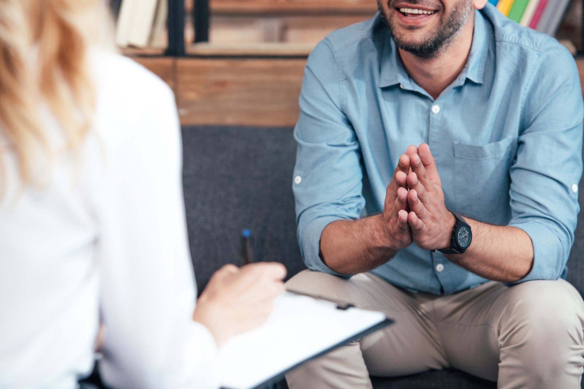 A man is sitting on a couch talking to a woman.