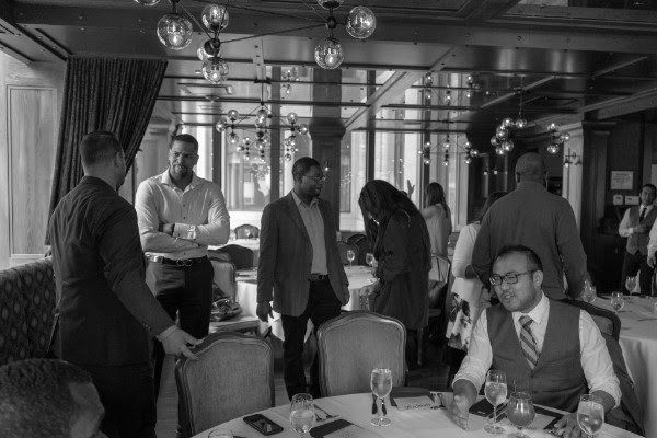 a group of people are sitting at tables in a restaurant .