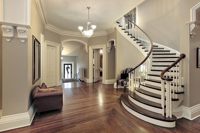 There is a curved staircase in the middle of the hallway.