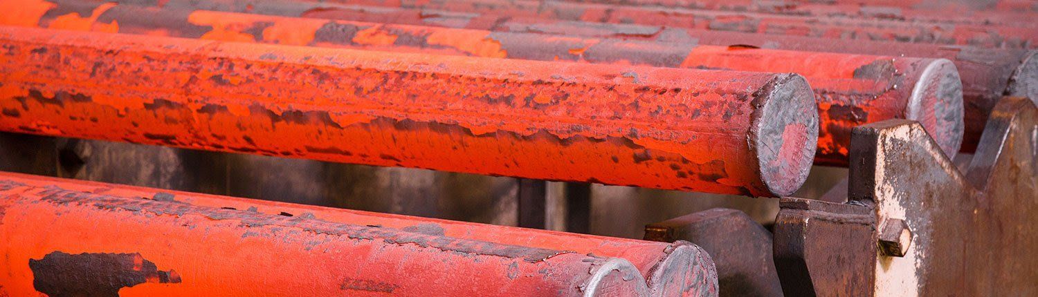A close up of a bunch of orange pipes sitting on top of each other.