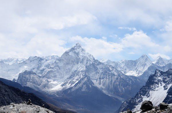 A snowy mountain range with a blue sky in the background