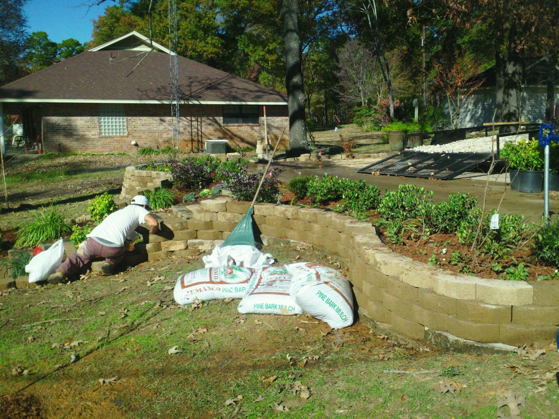 Worker Installing Retaining Wall — Tyler, TX — Creative Landscape Solutions