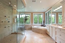 bathroom remodeling project completed with white cabinet, tile floor and clear glass shower