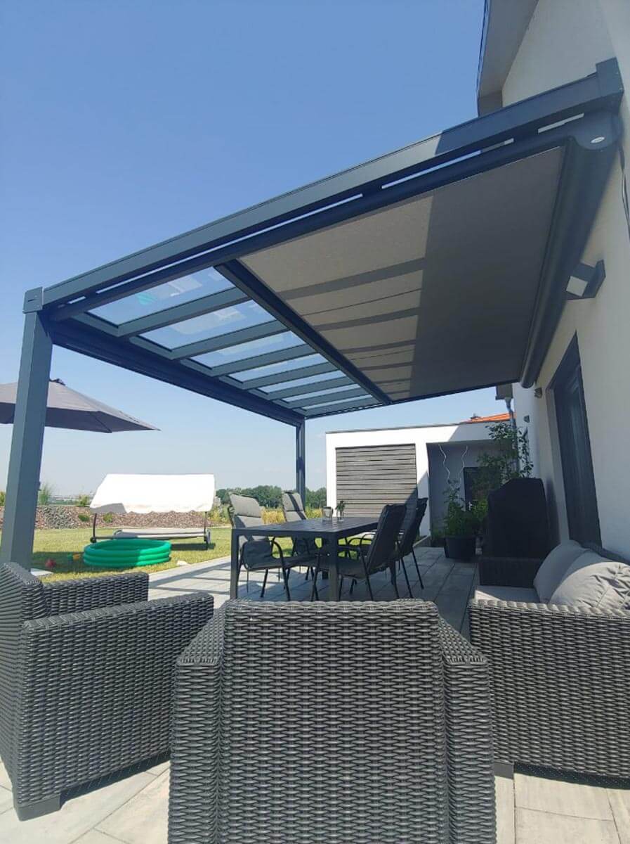Eine Terrasse mit Tisch und Stühlen unter einem Baldachin.