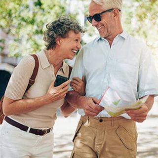 Retired Couple Walking Around the Town — Medicare Plans in Bozeman, MT Retired Couple Walking Around the Town — Medicare Plans in Bozeman, MT
