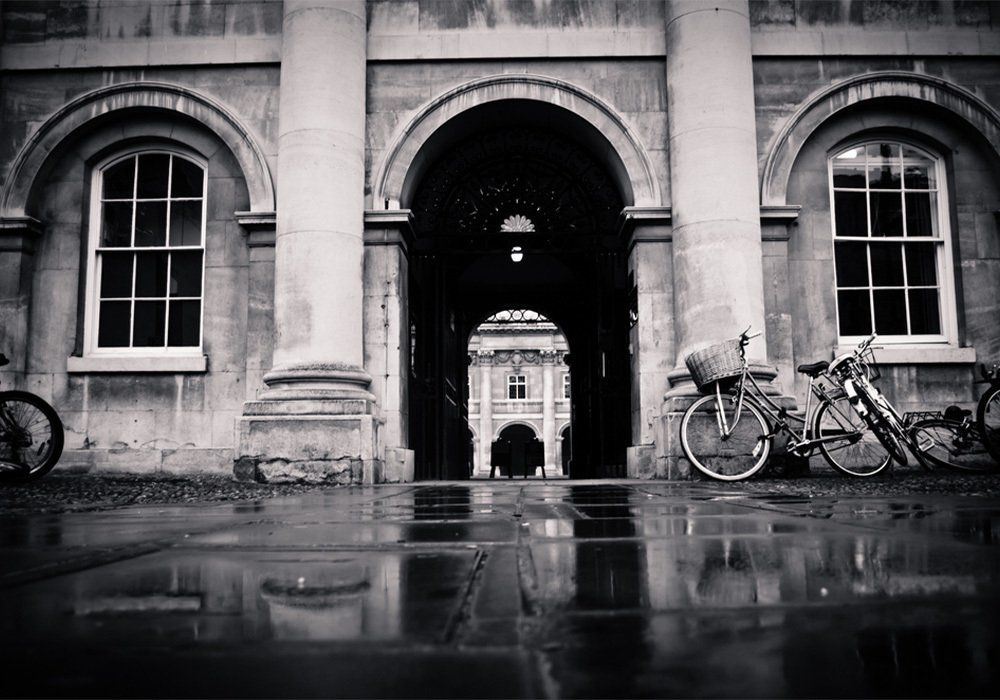Cambridge, UK. Bicycles are near the arch of the entrance to the yard