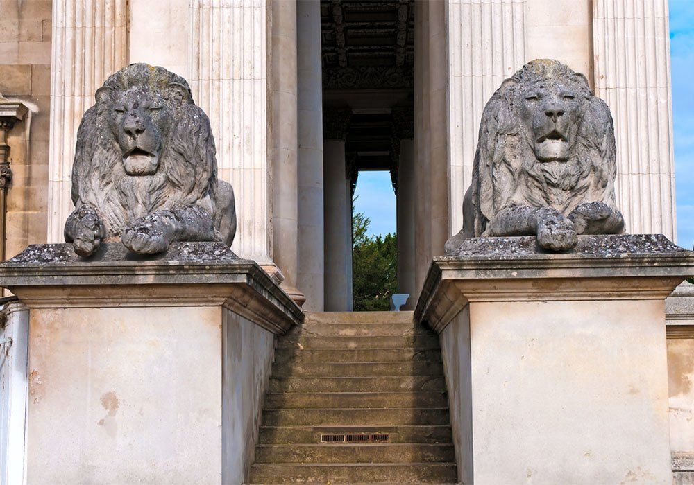 Stone lions at doorway Two sculptured lions guarding the stairs and entryway to the Fitzwilliam Museum, Cambridge, UK.