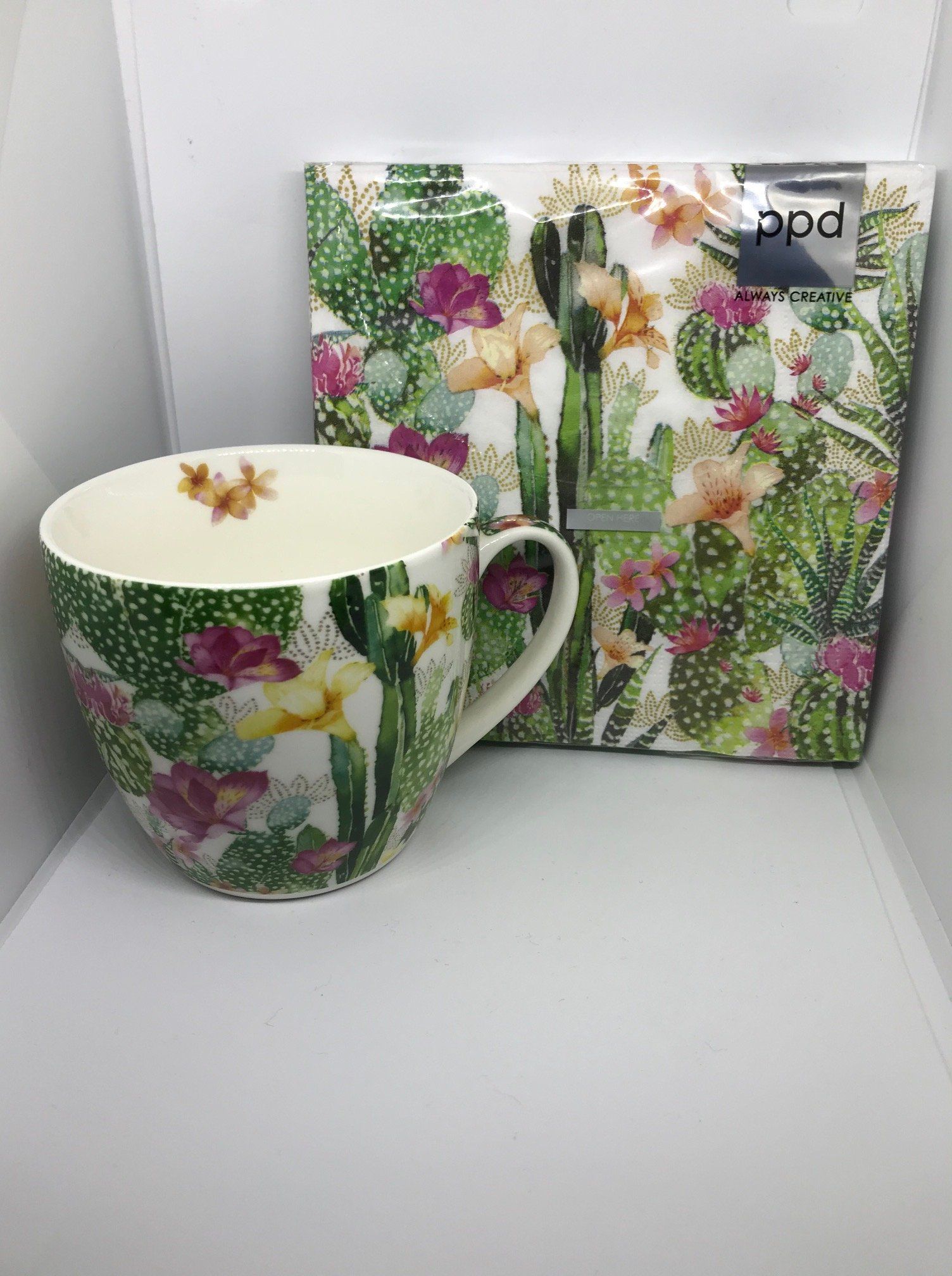 Mok en servettenset met cactus- en bloemenmotief in groen, roze en geel.
