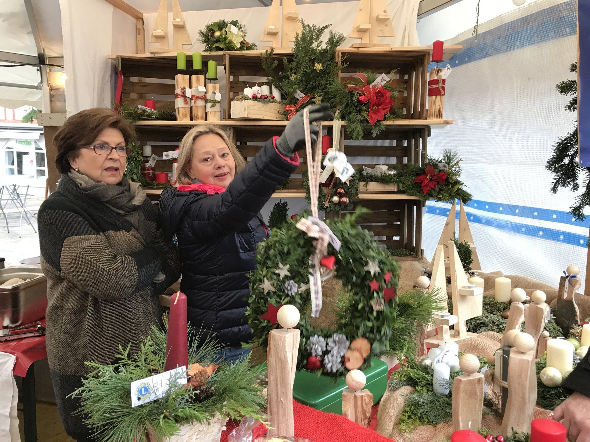 Zwei Frauen stehen vor einem weihnachtlich dekorierten Tisch.