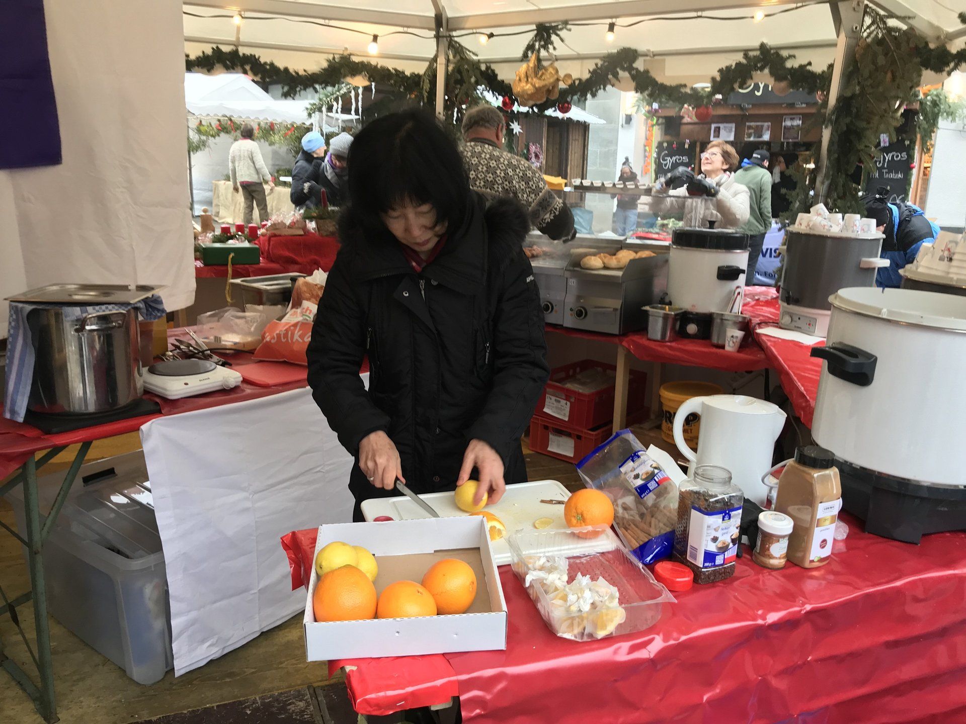 Eine Frau schneidet Orangen auf einem Tisch auf einem Markt.