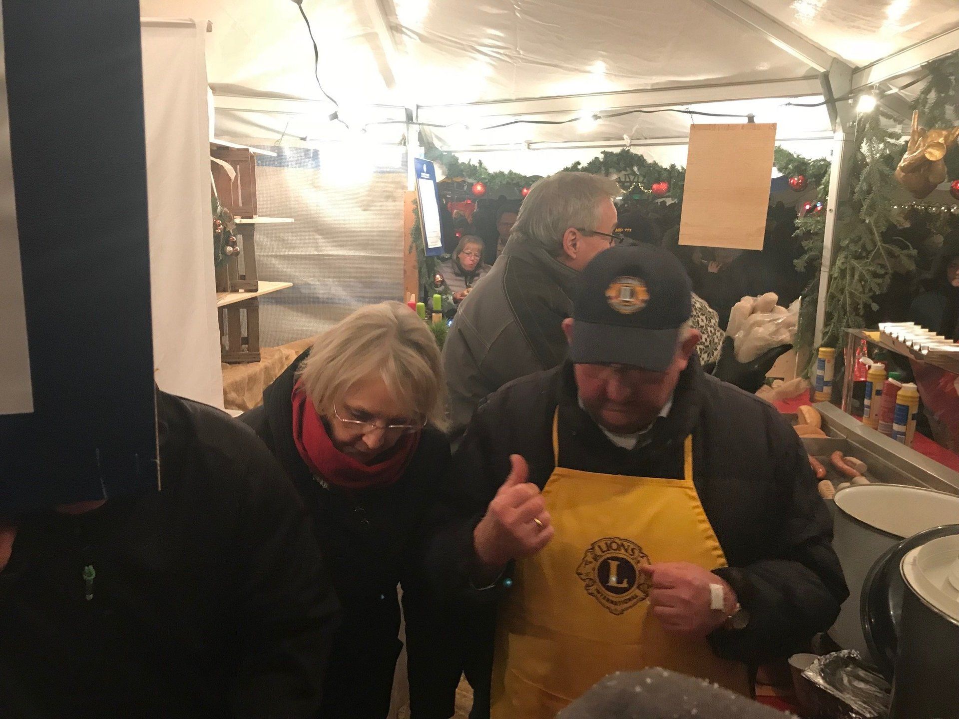 Ein Mann und eine Frau stehen nebeneinander in einem Zelt und strecken den Daumen nach oben.