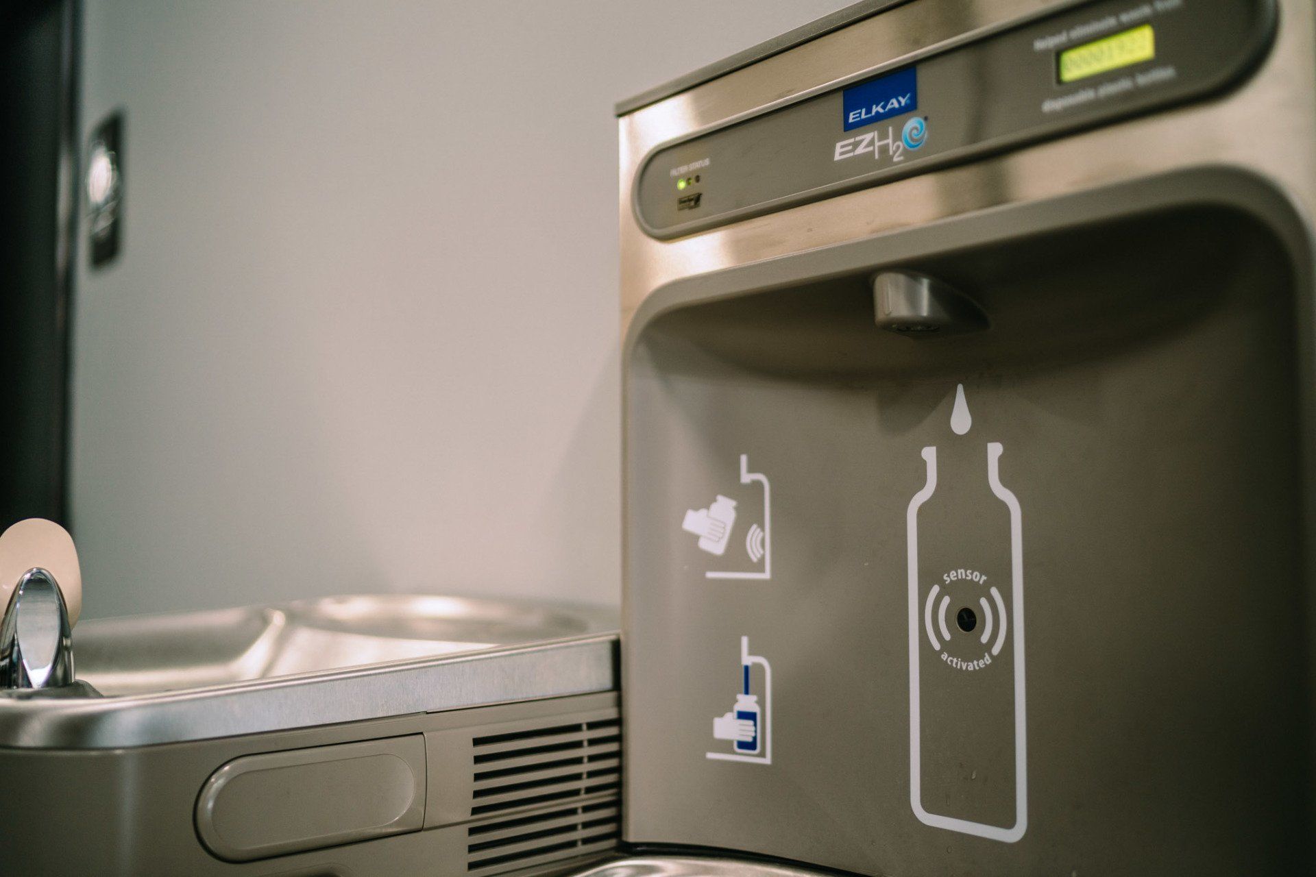 A close up of a water fountain with a bottle on it.