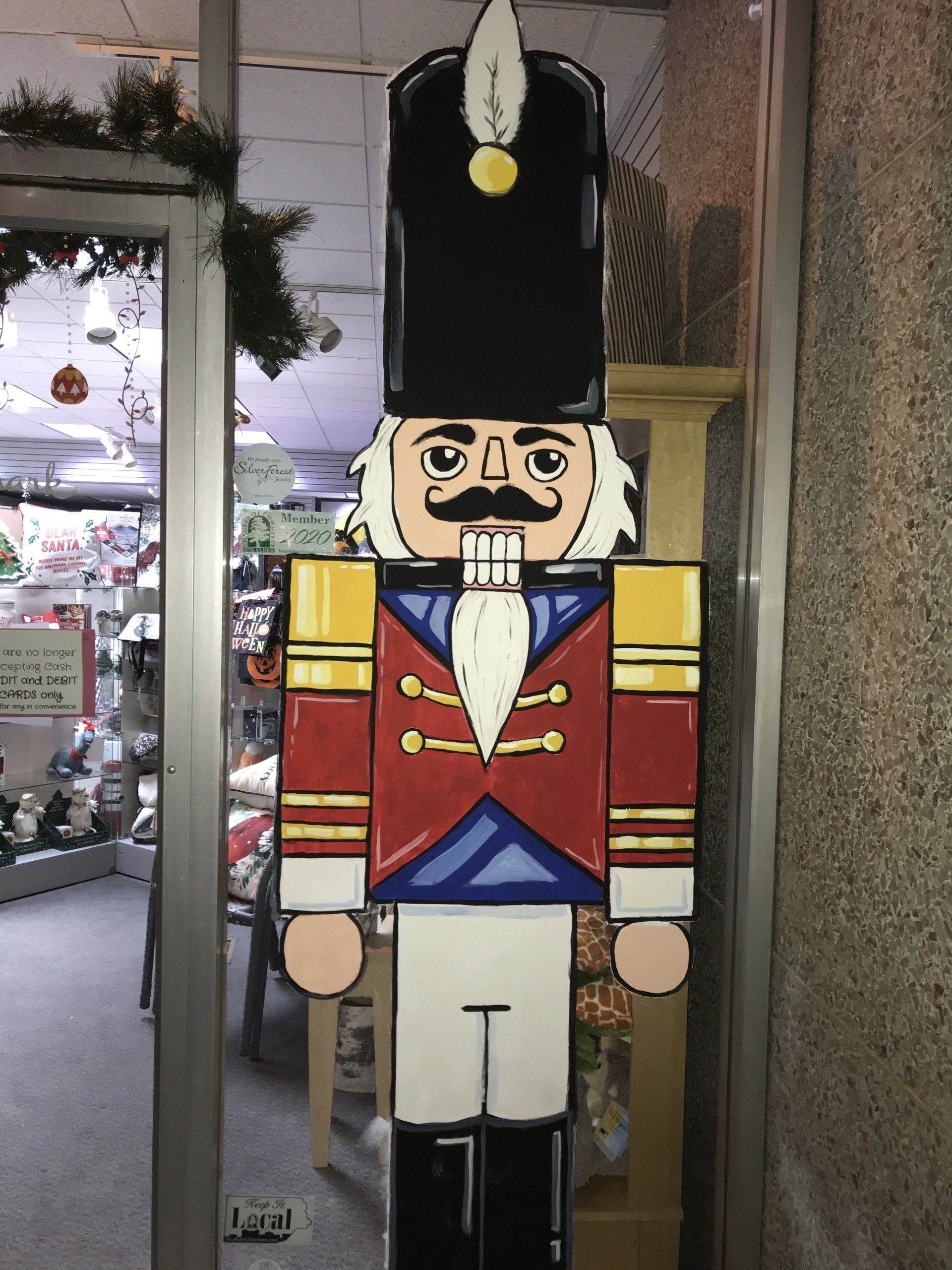 A nutcracker is standing in front of a glass door