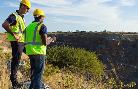 Two male workers surveyors at mining site Two male workers surveyors at mining site