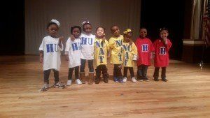 A group of young children are posing for a picture on a stage.