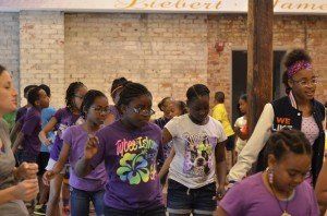A group of young girls are dancing in a room.