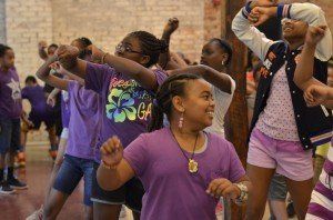 A group of young girls are dancing in a gym.