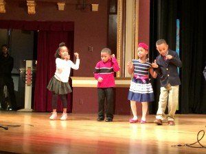 A group of children are dancing on a stage.