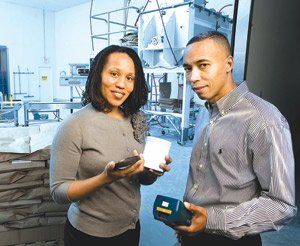 A man and a woman standing next to each other holding boxes