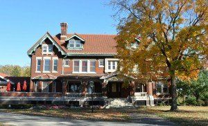 A large brick house with a tree in front of it