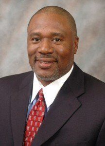 A man in a suit and tie is smiling for the camera