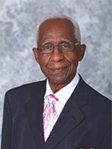 A man in a suit and tie is smiling for the camera.