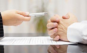 A pen being handed to a man