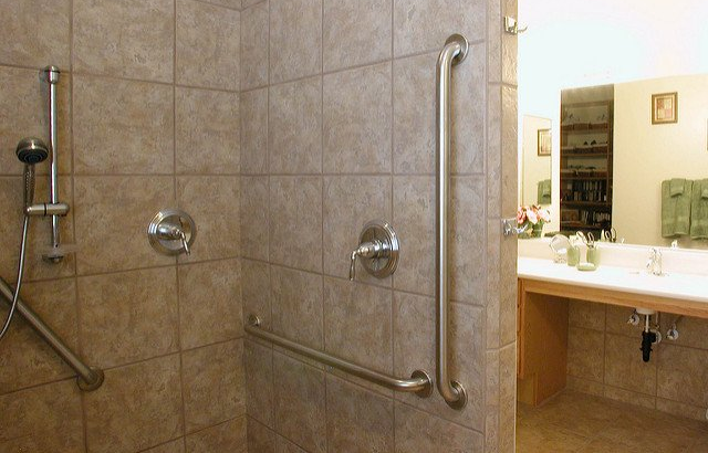 A bathroom with a walk in shower and a sink