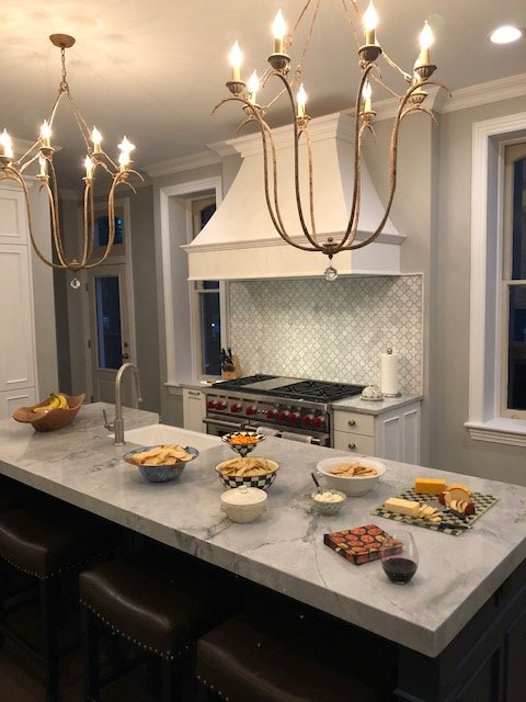 A kitchen with a large island and a stove top oven